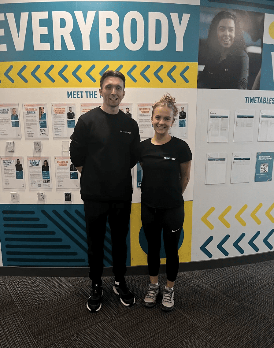 a PT and grace standing in front of a poster