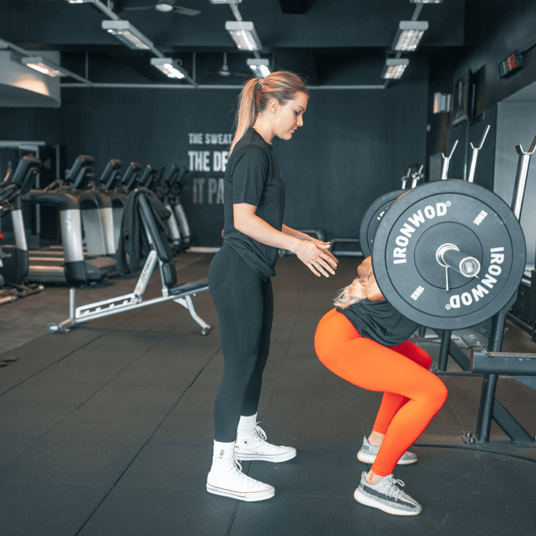 2 Female Students Squat at our PT Course in Manchester