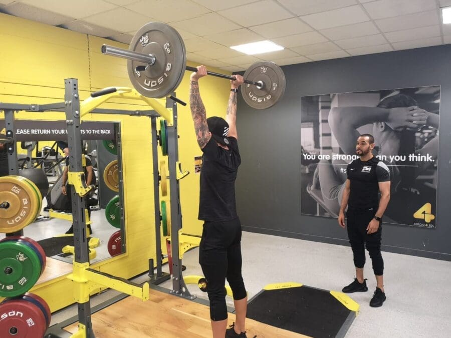 strength and conditioning coach with client in the gym