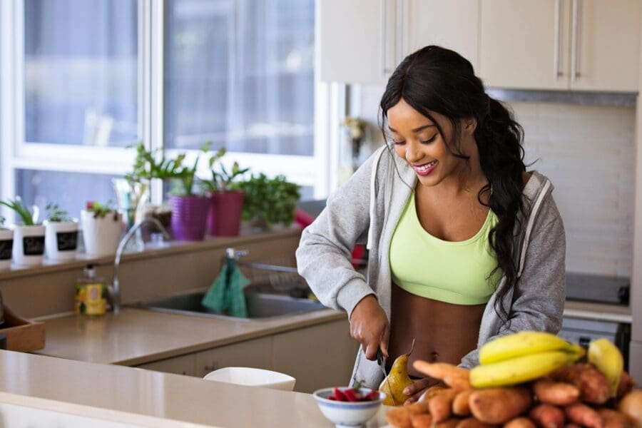 nutritionist salary uk female cutting food in kitchen