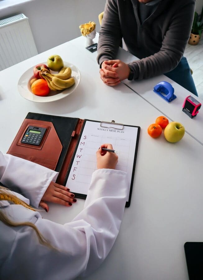 dietitian vs nutritionist professional at desk with client dietitian vs nutritionist professional at desk with client