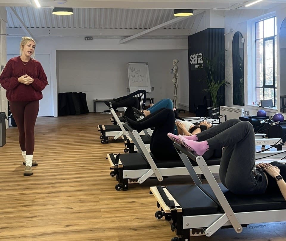Reformer Pilates training course being supervised by a Pilates tutor.